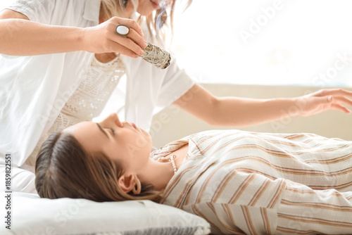 Healer cleansing young woma...