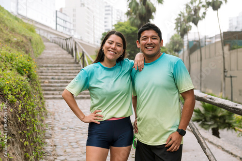 Multiracial, athletic couple smiling after training outdoors on a sunny morning