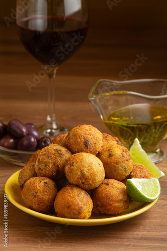 Cuadro en lienzo Cod fritters, a glass of red wine, black olives, and olive oil
