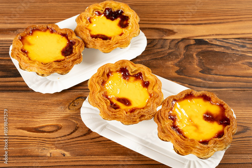 angle view portuguese egg tarts on a wooden table at horizontal composition