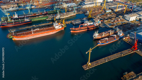 Obraz na plátne Drone shot of multiple cargo ships and tankers moored at the shipyard docks wait