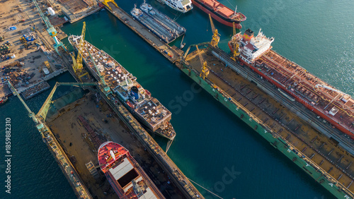Fotografija Aerial shot of a shipyard dock containing a blue and white passenger ship underg