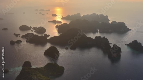 Sunrise illuminates rock islands, composed of ancient, uplifted reefs, rising from the seascape in Misool, Indonesia. This region harbors spectacular marine biological diversity and is a popular desti