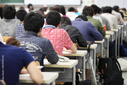 Photos 日本の大学の大教室で机に並んで勉強する男子学生の後ろ姿 キャンパスライフ 教育　大学生のイメージ
