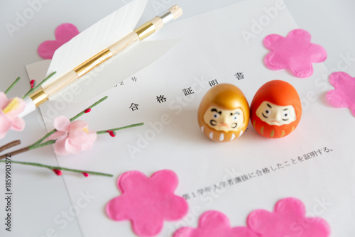 Foto 入学試験の合格証書と、合格祈願のだるま、破魔矢と桜の花びら　合格のイメージ 大学受験 高校受験 中学受験 中受 お受験