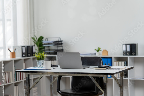 Φωτογραφία Minimalist Workspace Design: A contemporary office space featuring a desk, laptop, plants, stationery, and a comfortable chair, creating a conducive environment for productivity and focused work