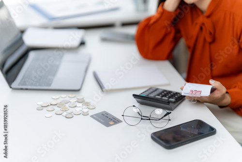Financial Frustration: A person, surrounded by financial tools, grapples with the complexities of budgeting and personal finance, highlighting the emotional strain of money matters.