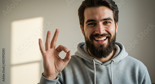 Smiling man giving okay gesture with hand