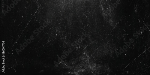 A dark and grainy texture with scratches and imperfections across a black surface creating a distressed aesthetic