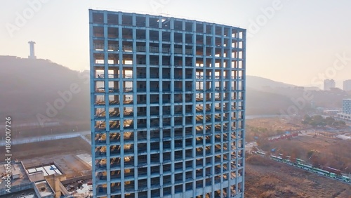 unfinished high-rise building, construction stalled due to financial deficit, reflecting economic challenges and abandoned urban development.