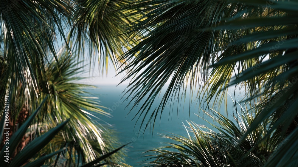 Fototapeta premium Lush Tropical Palm Fronds Framing a Serene Azure Ocean View Under Bright Sunlight