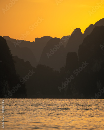 Golden Sunrise Over Limestone Mountains at Cheow Lan Lake, Thailand