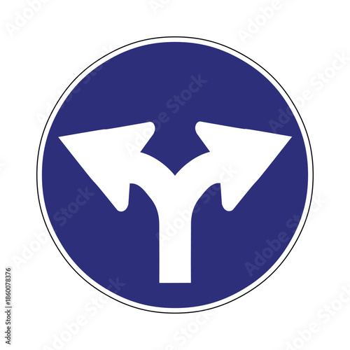 Blue circular road sign with white split arrows, directional fork in the road and navigation symbol
