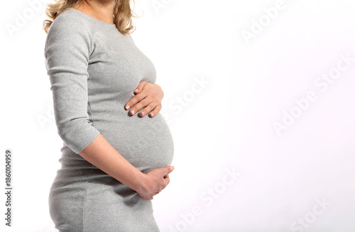 Pregnant woman wearing a light dress on a white background, expressing purity, motherhood, calm ожидание, and gentle feminine beauty