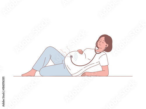 Pregnant woman lying down listening to baby heartbeat with stethoscope.