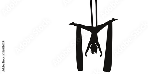 Silhouette of woman performing aerial acrobatics on silk ribbons