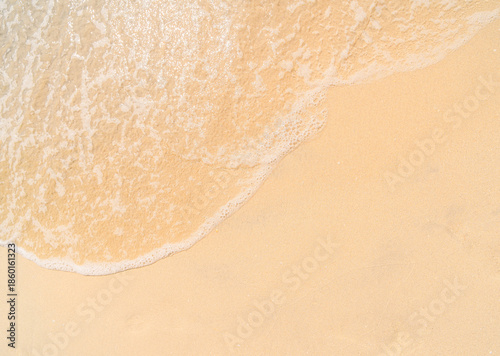 Quadro em tela A close-up, high-angle of a gentle white-foamed ocean wave washing onto a smooth