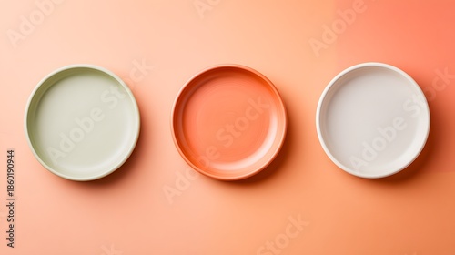 Top Down View of Three Colorful Ceramic Plates on a Solid Peach Background