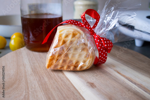 Heart‑shaped waffle wrapped with ribbon.