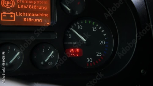 Truck dashboard. Tachometer shows engine RPM. Digital time 15:19. Warning messages. EBS brake system malfunction. Alternator fault. Critical vehicle issues visible.