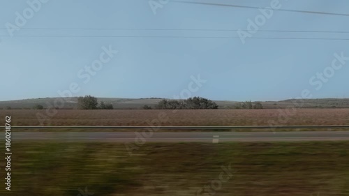 Vehicles travel through rural landscape.