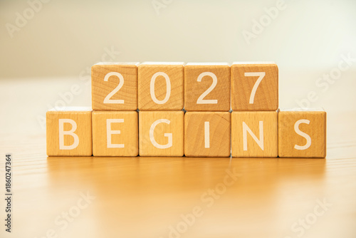 Wooden cube blocks 2027 begins background. Texts and numbers on wooden blocks with copy space. 2026 happy new year idea concept.