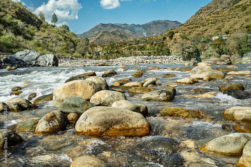 Obraz premium Rocky Mountain River with Clear Flowing Water and Scenic Landscape