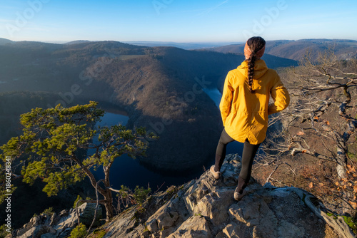 Girl standing on a stone above the Vltava River in the Czech Republic