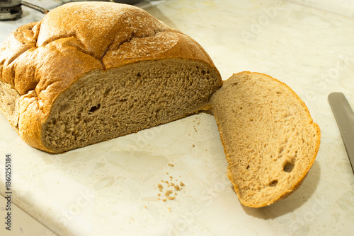 Large Sliced Loaf of Fresh Brown Bread on a Kitchen Countertop