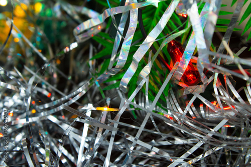 Close-up of Silver Tinsel and Colorful Festive Lights on a Christmas Tree