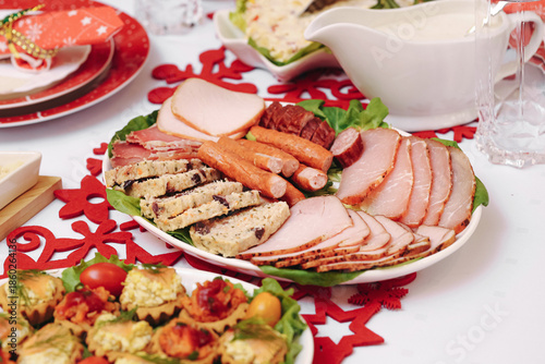 Wallpaper Mural Cold cuts platter on festive table. Sliced ham sausage and roast meat. Christmas family dinner food. Traditional holiday meal setting. White tableware and red decoration. Seasonal celebration cuisine. Torontodigital.ca