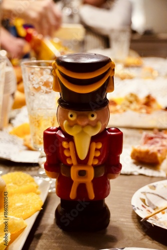 Holiday dinner table decoration with a classic nutcracker and festive food platters.