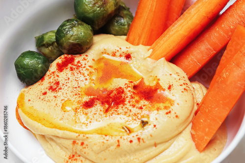 Wallpaper Mural Homemade hummus with olive oil and paprika. Creamy chickpea dip on white plate. Fresh carrot sticks and brussels sprouts. Healthy vegetarian snack. Simple clean food photography scene. Torontodigital.ca