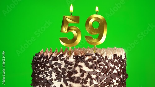 Lighting number 59 golden birthday candle on festive cake. Green screen, chromakey. Birthday cake on 59th anniversary