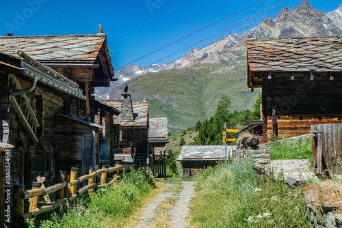 Old wooden houses on the slopes of the Swiss Alps in summer.