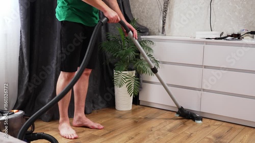 Household cleaning at home - man vacuuming the floor. High quality 4k footage