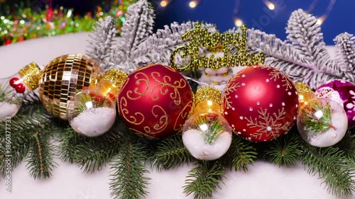 Large balls and decorated lights in the middle lie on Christmas tree branches on a blue background