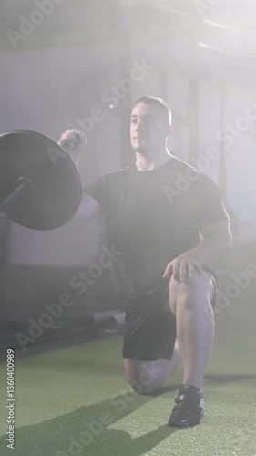 Fitness man exercise landmine press with barbell while kneel weightlift in gym