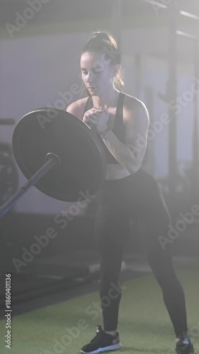 Fitness woman exercise landmine squat with barbell weightlifting in dark gym