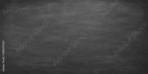 A dark and weathered blackboard surface featuring a blank grunge texture with vintage gray chalk dust patterns on an aged, rough wall backdrop