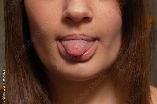 Vibrant Indoor Shot Of Youthful Woman Teasingly Sticking Out Her Tongue With Playful Charm