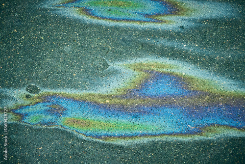 Bright oil spill on the road surface, generating an intriguing abstract background.