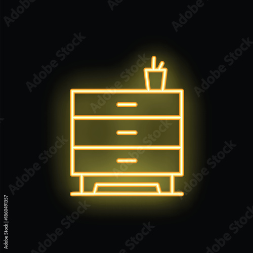 Yellow neon sign of a dresser with a cup and pencils on top illuminating a dark room
