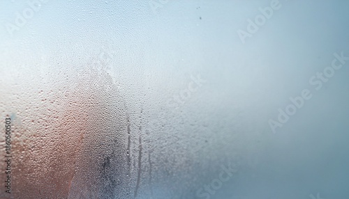 Close-up of condensation on a window, showing tiny water droplets and blurred background elements