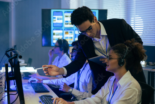 Foto Professional manager supervising a diverse customer support team with headsets in a modern office
