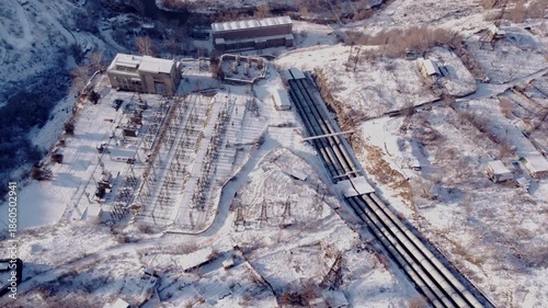 Large hydro electric power station pipes next to a power substation in the snowy mountains