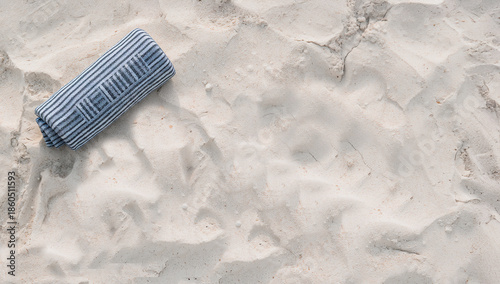 Toalha de praia dobrada sobre areia clara em conceito minimalista de verão