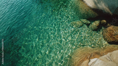 Clear water flows over rocks in a coastal area on a sunny day near a beach