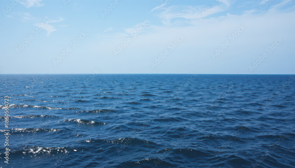 Fototapeta premium A serene ocean landscape with gentle waves under a blue sky