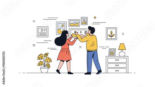 Young couple decorating living room wall with framed art